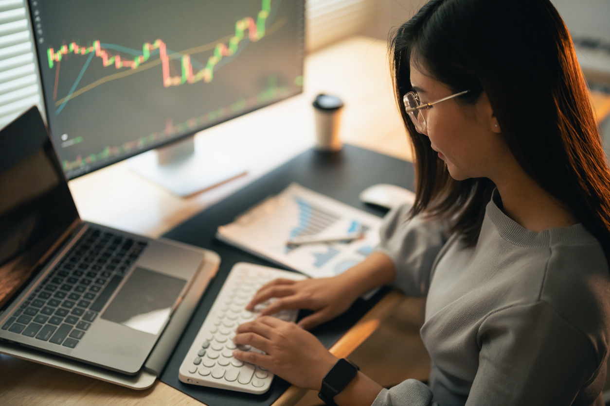 asian business woman is checking bitcoin or stock market price chart on the digital exchange on a laptop monitor computer, cryptocurrency future price action prediction. trading stock bitcoin etf.
