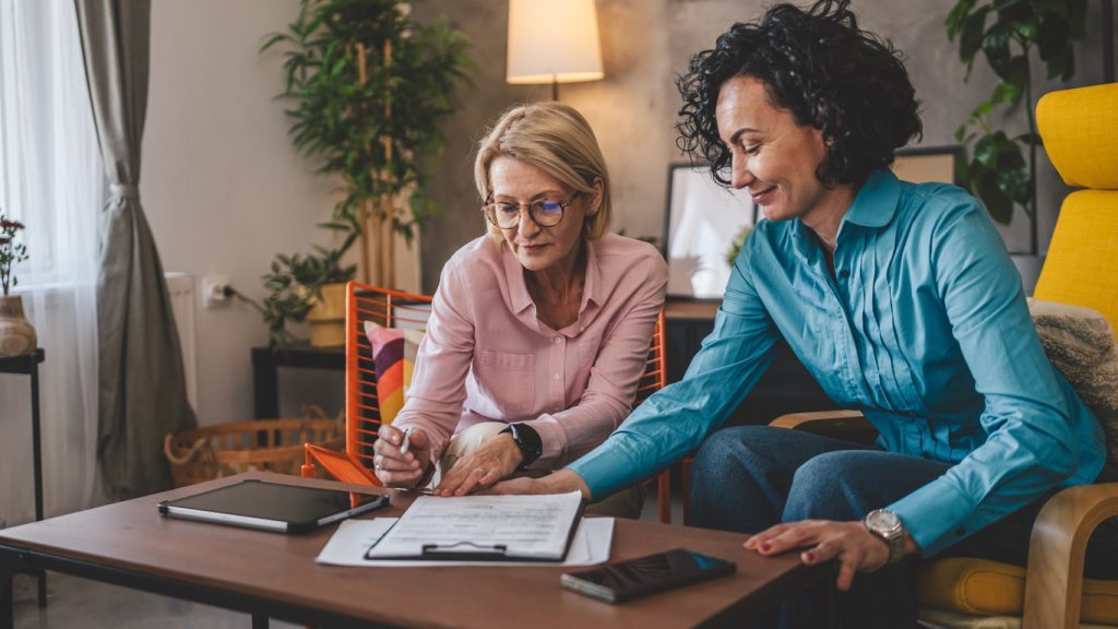 two women work from home sign contract document or insurance policy