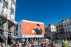 rolex advertising canvas at the puerta de sol, with photos of carlos alcazar with the champion cup celebrating the wimbeldon and roland garros tennis grad slam titles.