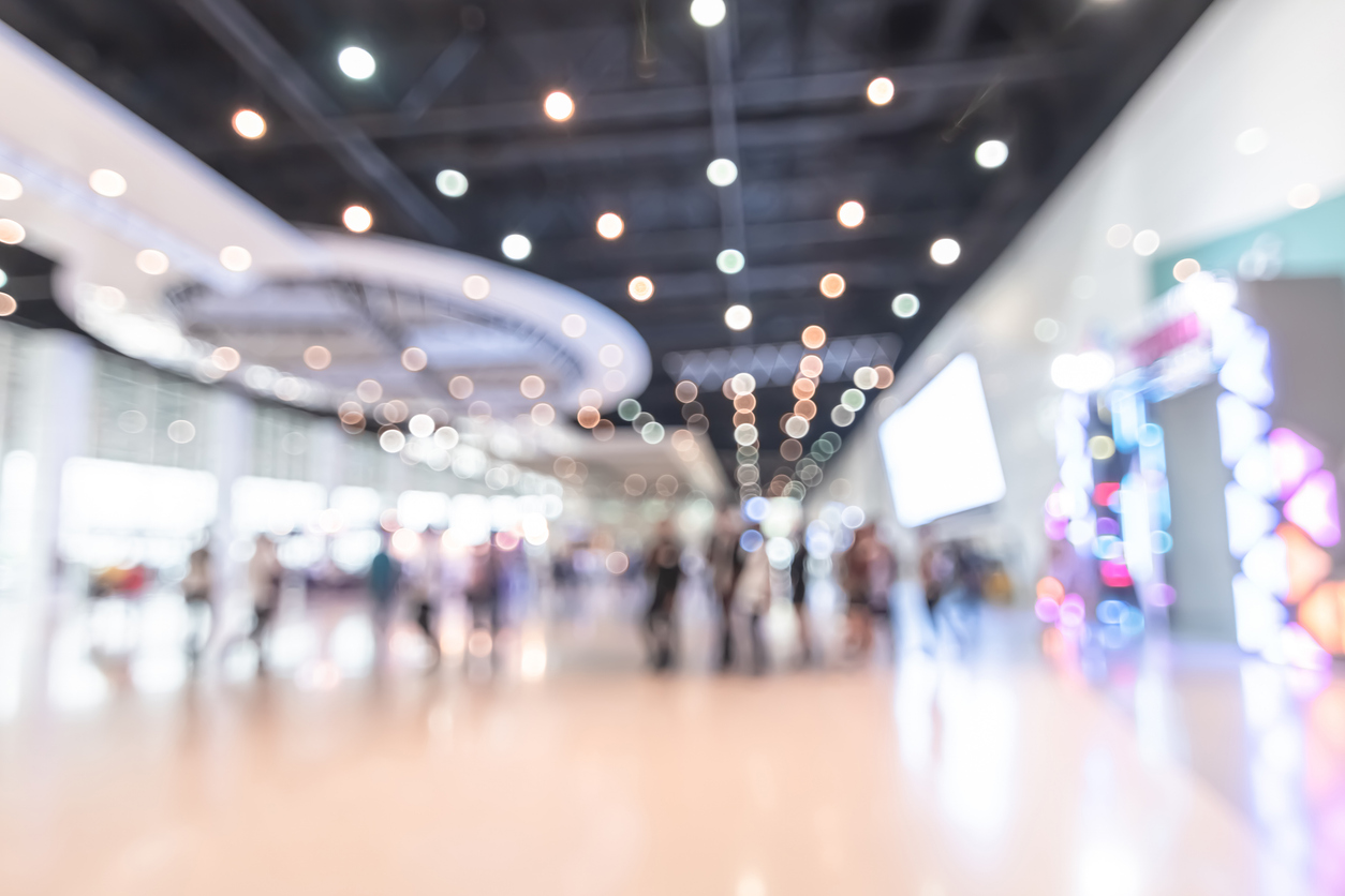 exhibition event hall blur background of trade show business, world or international expo showcase, tech fair, with blurry exhibitor tradeshow booth displaying product with people crowd
