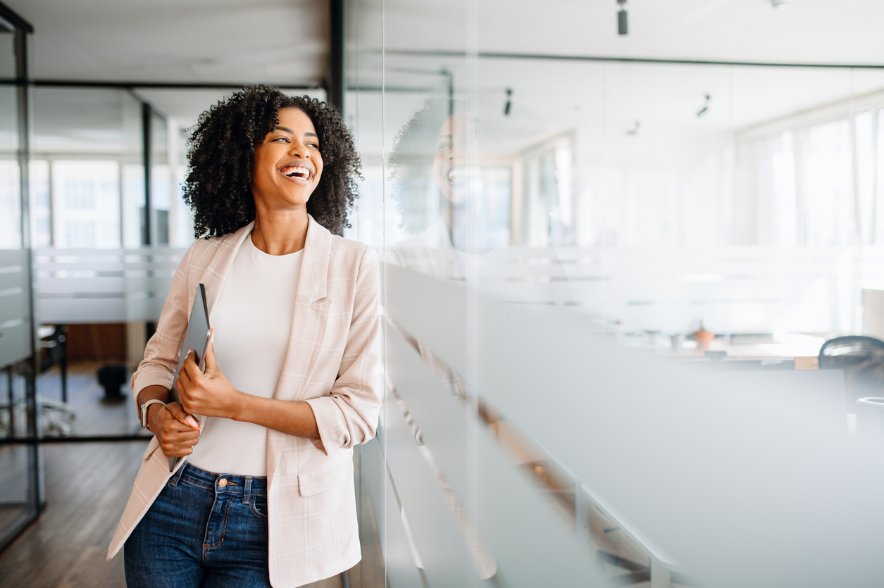 a young professional woman stands confidently in a modern office