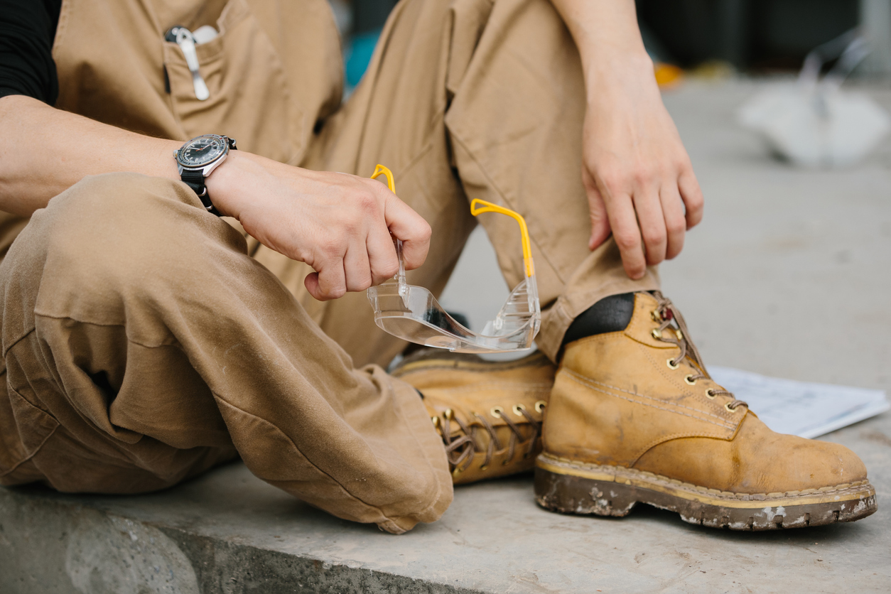 safety glasses in the hands of a worker.