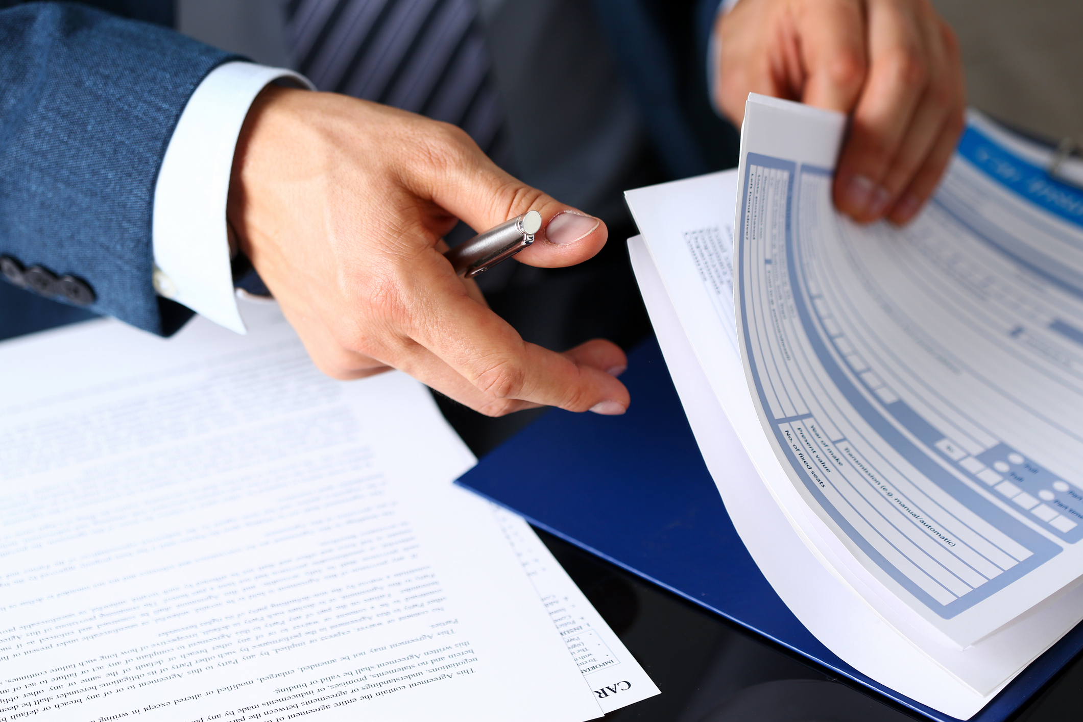 male arm in suit offer insurance form clipped to pad