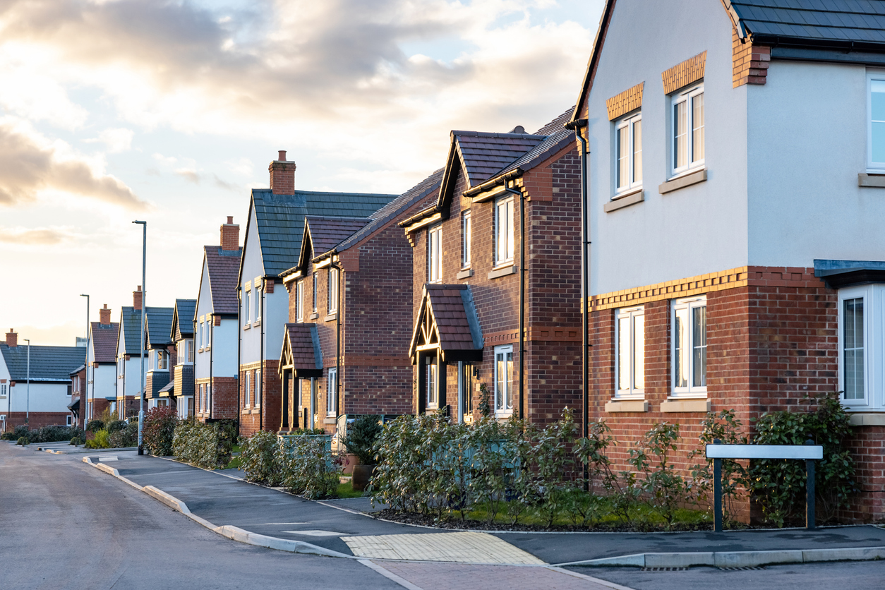 houses in england with typical red bricks at sunset main street in a new estate with typical british houses on the side real estate and buildings concepts in uk