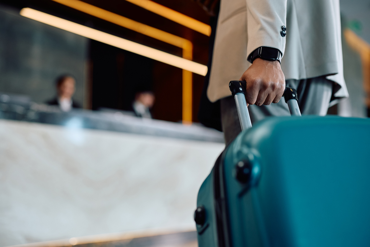 close up of black man with suitcase arriving at the hotel.