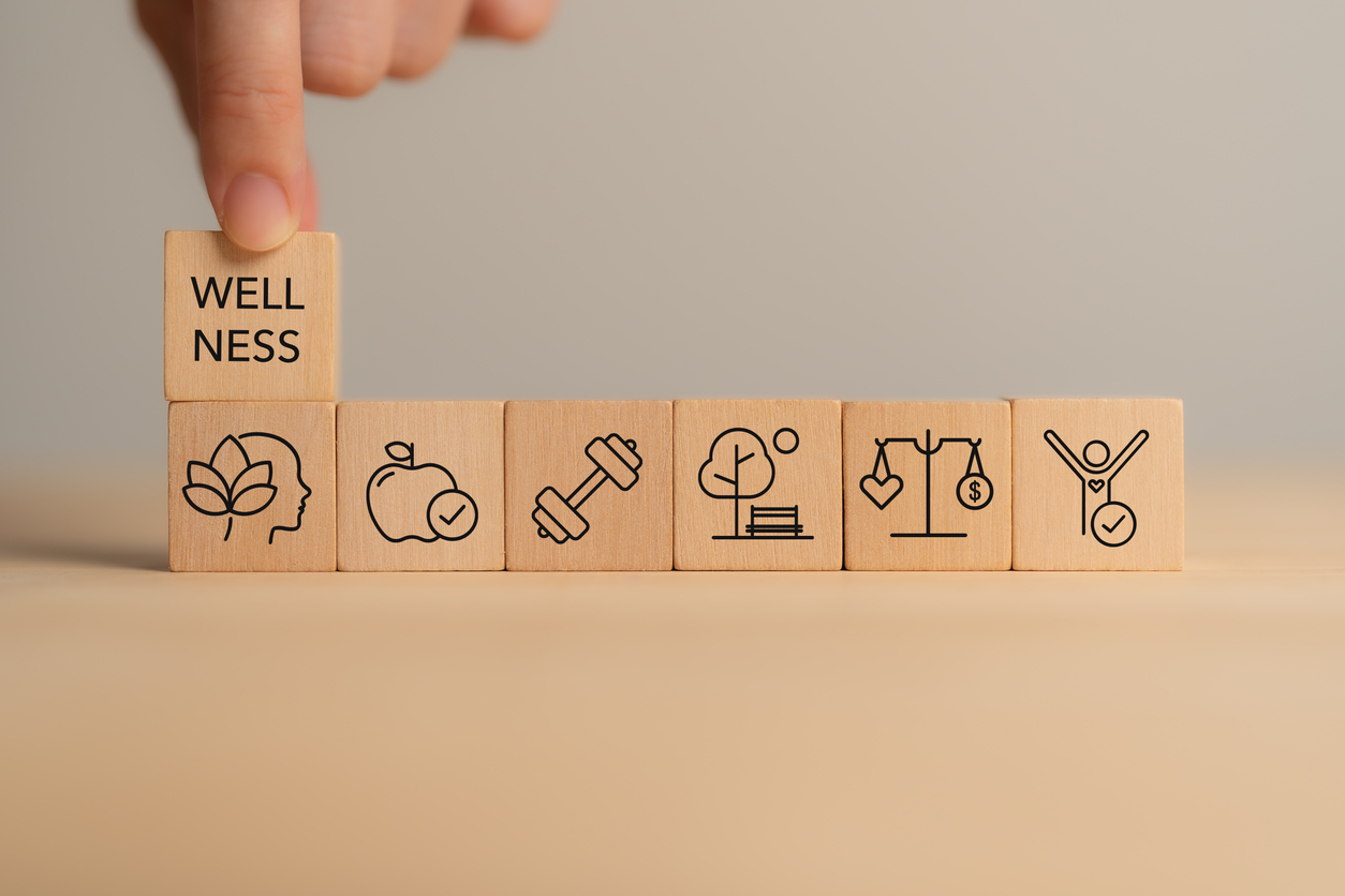 holistic wellness concept. wooden block with wellness icons, health care ,including mental well being, fitness, nutrition, sleep, relationships and financial balance. personal development and balance.