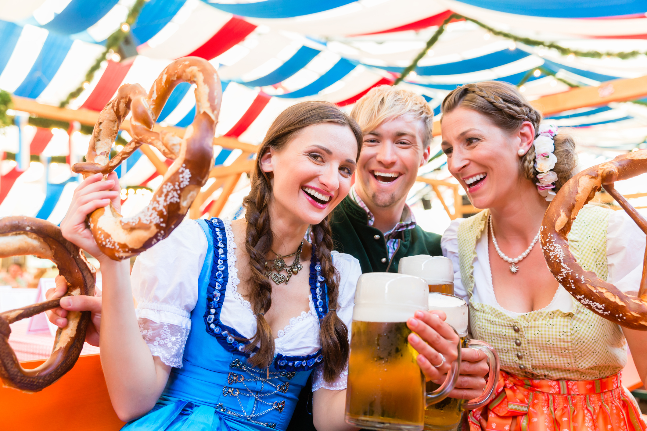 friends with giant pretzels in bavarian beer tent