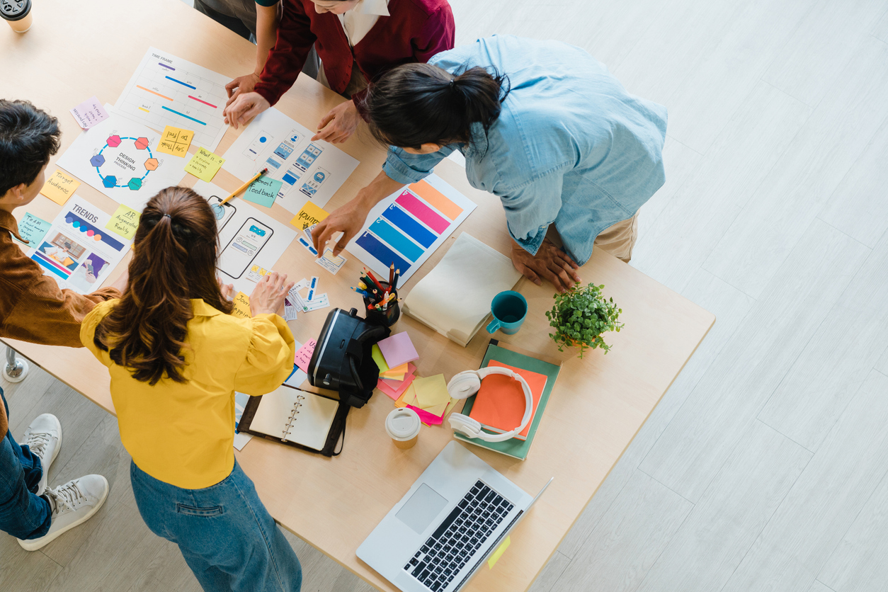 multiracial group of young creative people in smart casual wear discussing business brainstorming meeting ideas mobile application software design project in modern office.