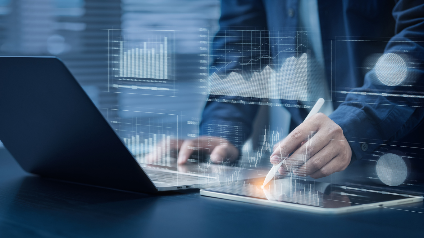 businessman uses computer with pen. financial graph analysis concepts stock market information. reporting and statistics including kpi analysis on a blue background.