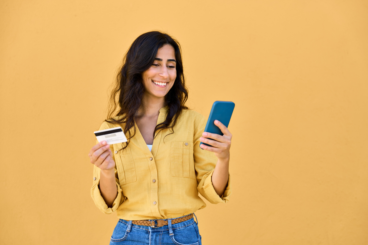 young middle eastern businesswoman holding mobile cell phone, debit credit bank card isolated. indian, arabian female shopper, business woman using smartphone for shopping, buying, e commerce online
