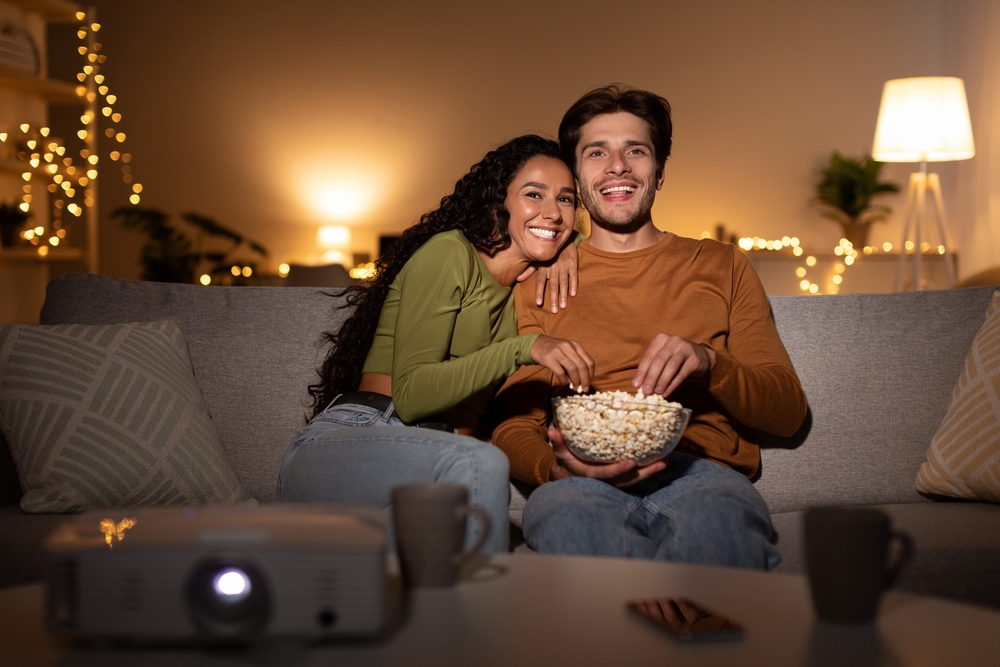 couple,watches,movie,via,domestic,cinema,projector,and,eats,popcorn