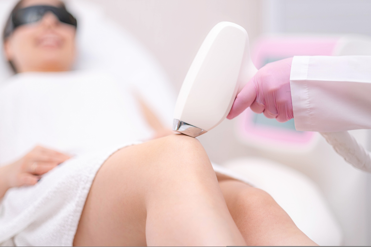 diode laser hair removal, beautician removes hair on beautiful female legs, hair removal for smooth skin, laser procedure at beauty studio or clinic, body care epilation treatment