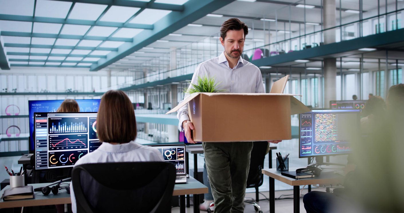 employee in office packing up box after resignation meeting