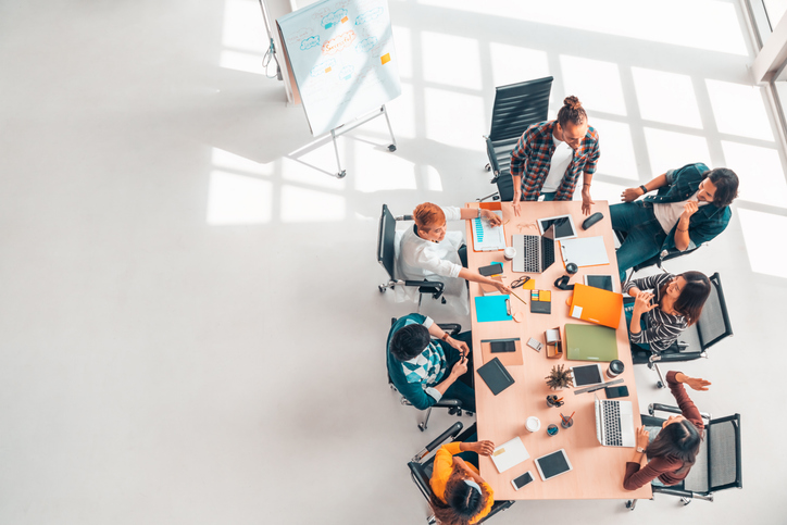 multiethnic diverse group of business coworkers in team meeting discussion, top view modern office with copy space. partnership professional teamwork, startup company, or project brainstorm concept