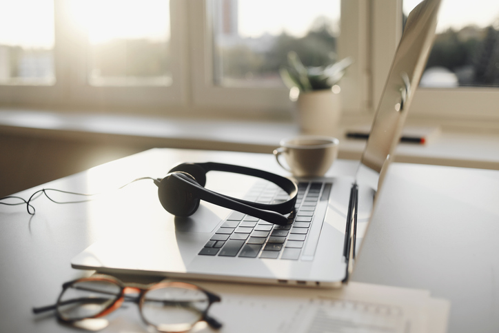 work place in office, headset, laptop computer, glasses at office desk