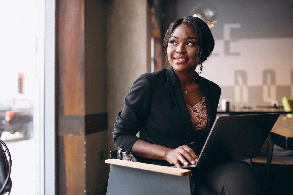 A confident professional woman works on her laptop, planning her next career move and embracing new opportunities later in life.
