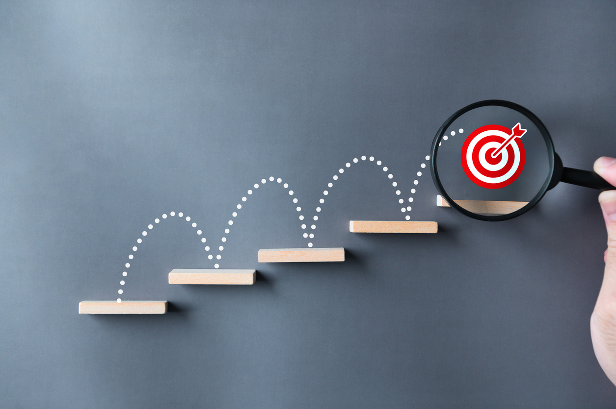 unlock potential of business success stairs dart and dartboard targets magnifying glass with hand on gray background. explore opportunities growth embrace steps to achieve ambitions and goal concept.