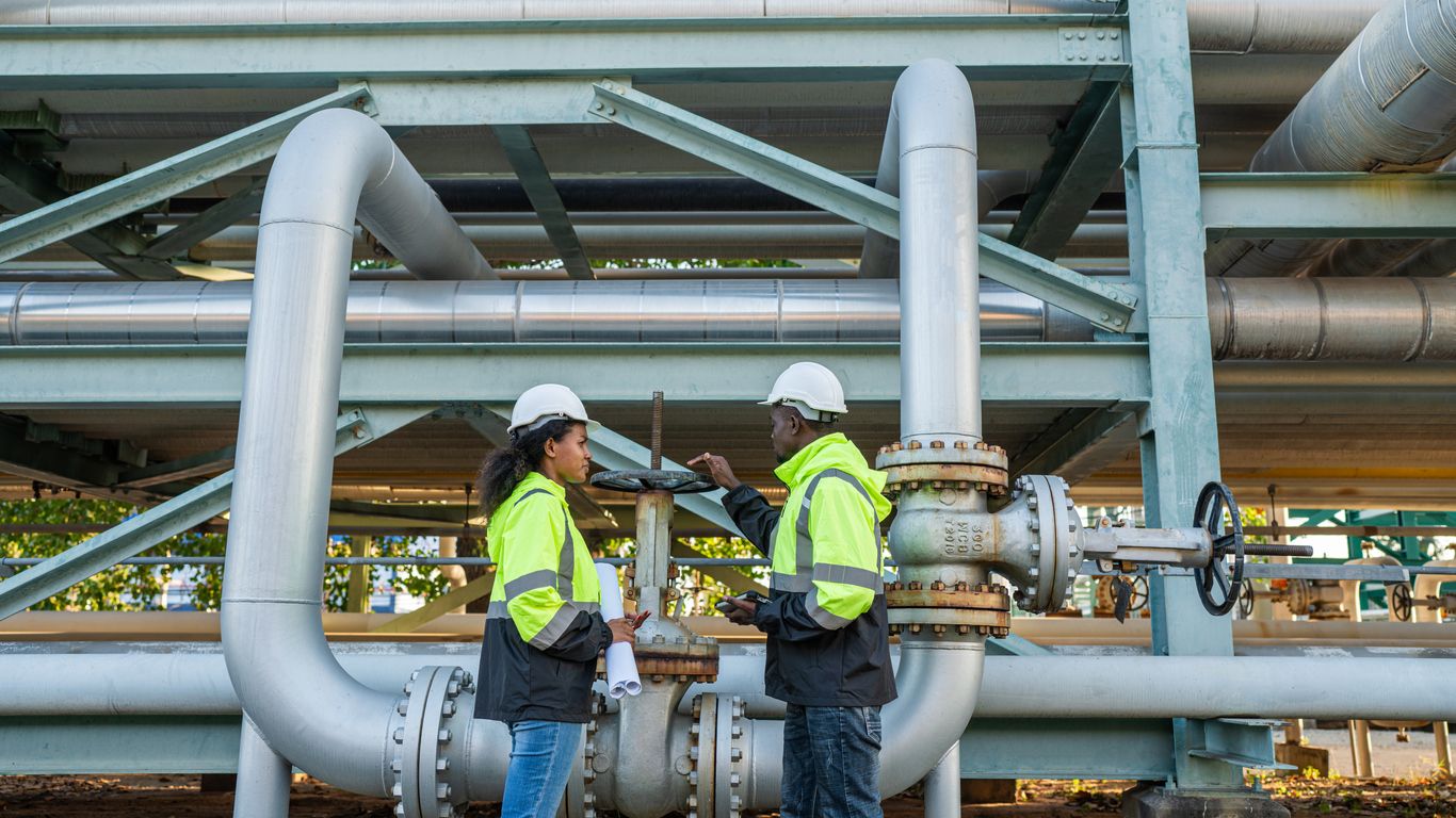 young mechanical engineer working and holding tablet to checking and inspection gas pipeline system.