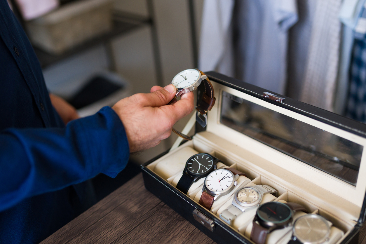 man selects a wristwatch from his collection to wear
