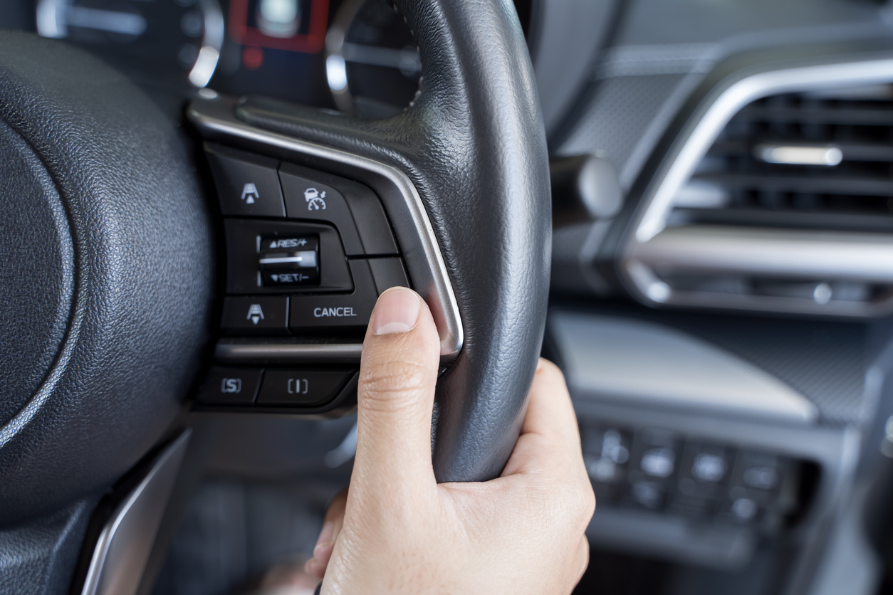 woman's hand presses the button on the steering wheel of the car close up. multi function buttons