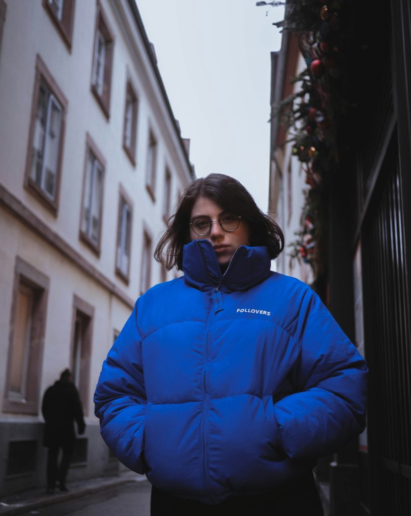 Woman in a blue jacket standing in the street