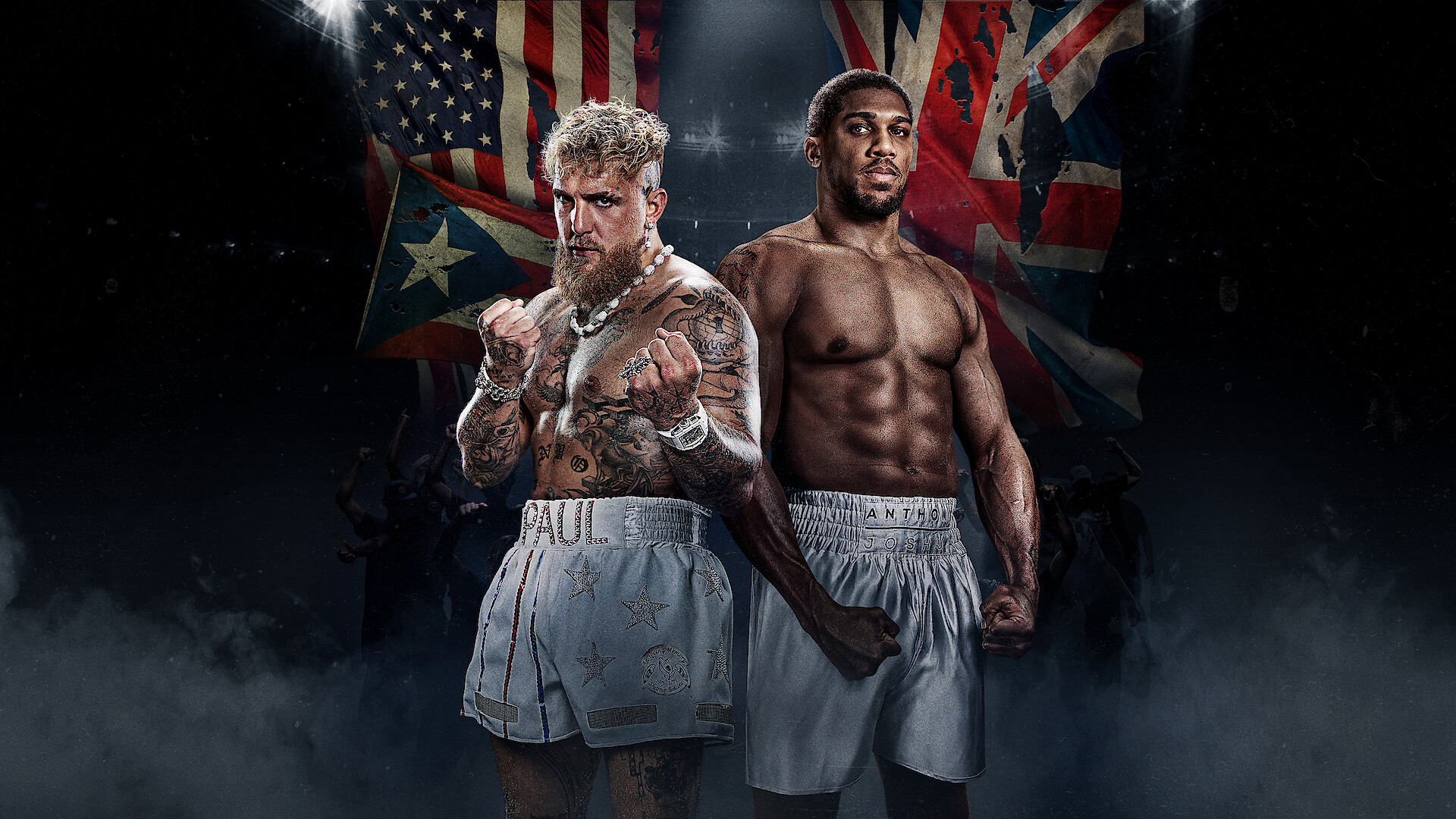 Jake Paul and Anthony Joshua standing face-to-face in boxing gear with U.S. and U.K. flags behind them in a promotional fight poster.