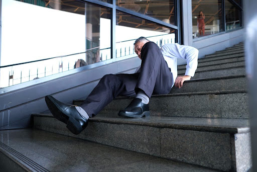 A man who has slipped and fallen on some stairs