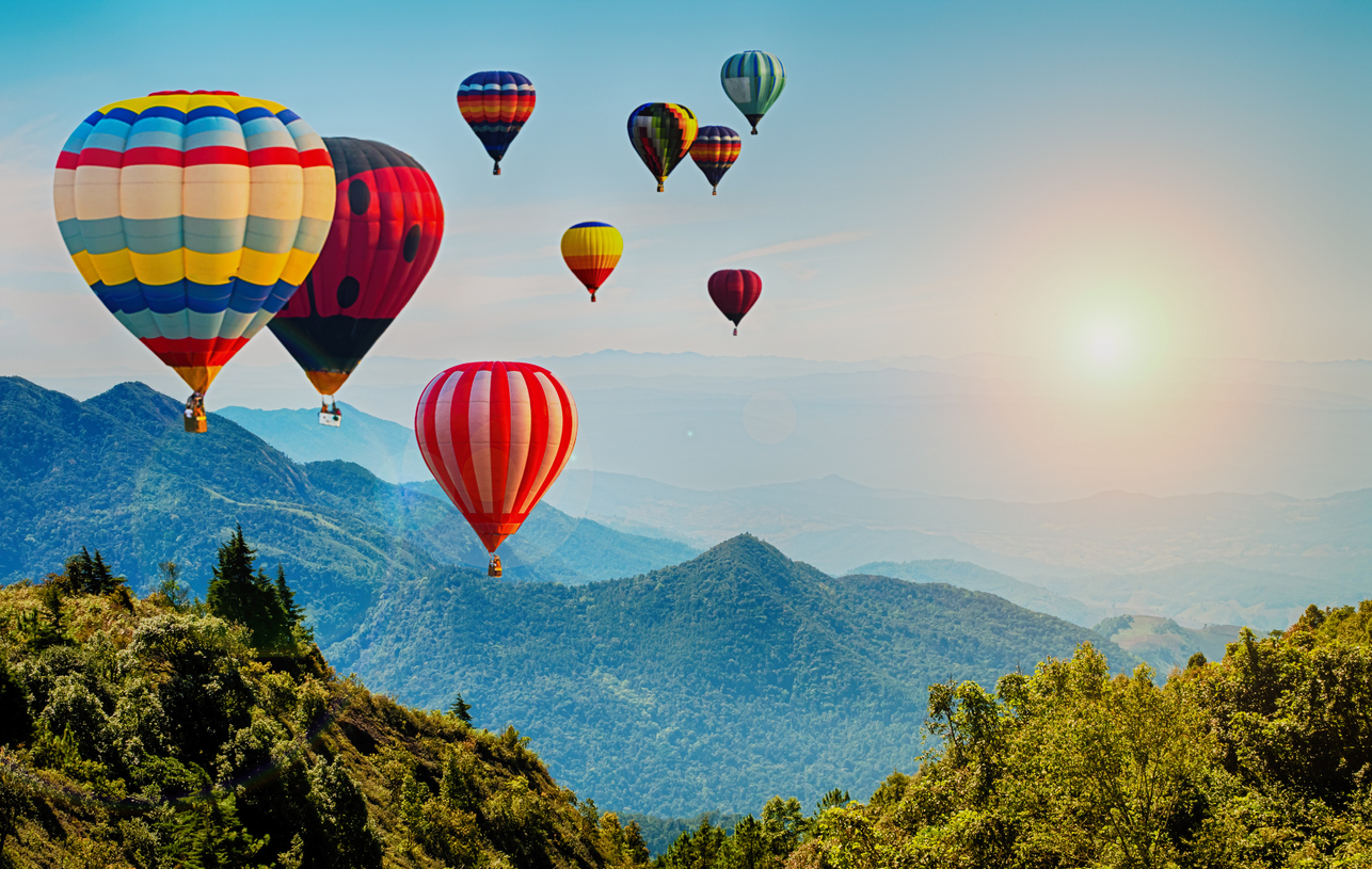 beautiful view of mountain with hot air balloons on morning at thailand.