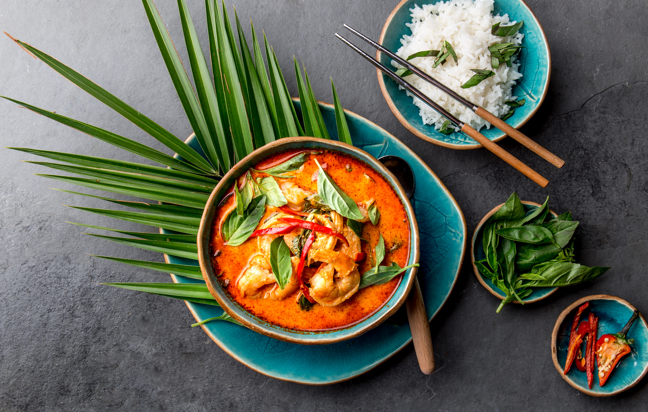 thai shrimps red curry. thailand thai tradition red curry soup with shrimps prawns and coconut milk. panaeng curry in blue plate on gray background