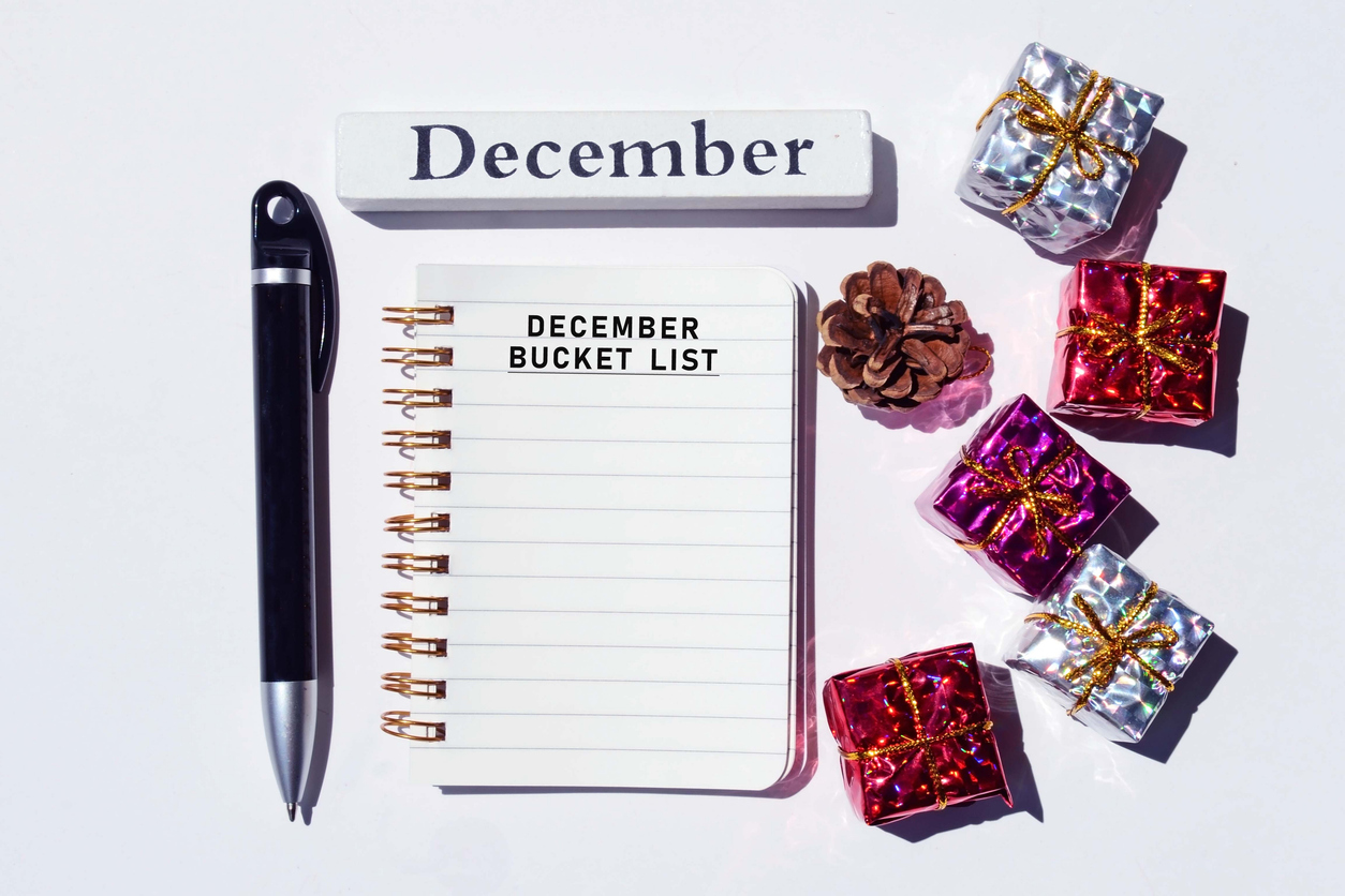 december bucket list written on notepad with christmas decorations background. merry christmas concept
