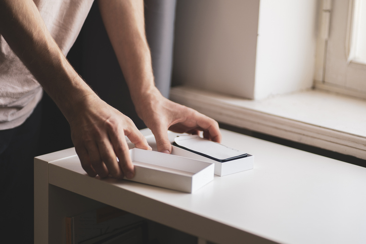 person holds the new smartphone box or case and unpack it, holiday surprise present concept