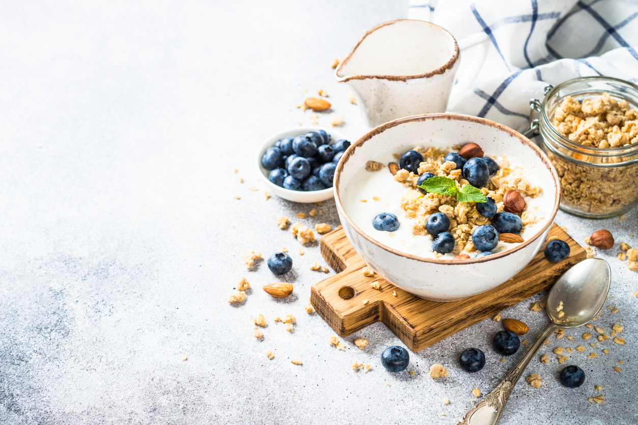 yogurt granola with fresh blueberries on stone table.