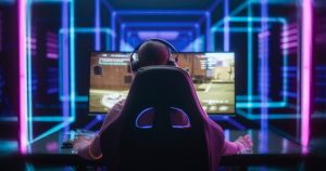 young female professional gamer competing in an e sports championship event in a futuristic neon arena. streamer girl playing video games online during cyber gaming tournament. back view footage