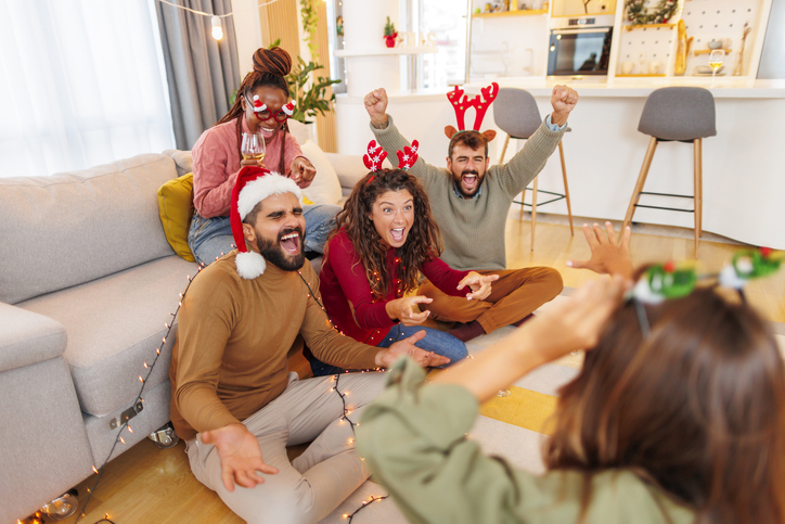 friends having fun playing charades while spending christmas day at home