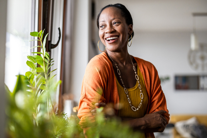 portrait of a smiling mature woman standing in her apartment
