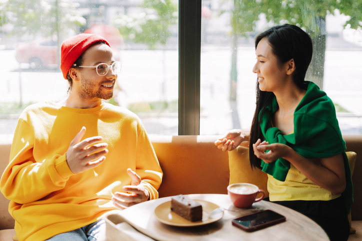 two friends, attractive woman and man enjoying coffee and conversation in a cafe