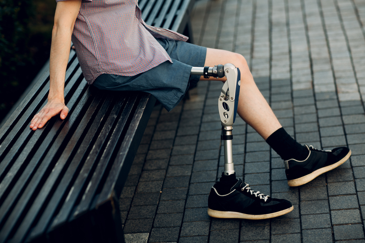low section of man with prosthetic equipment sitting on bench
