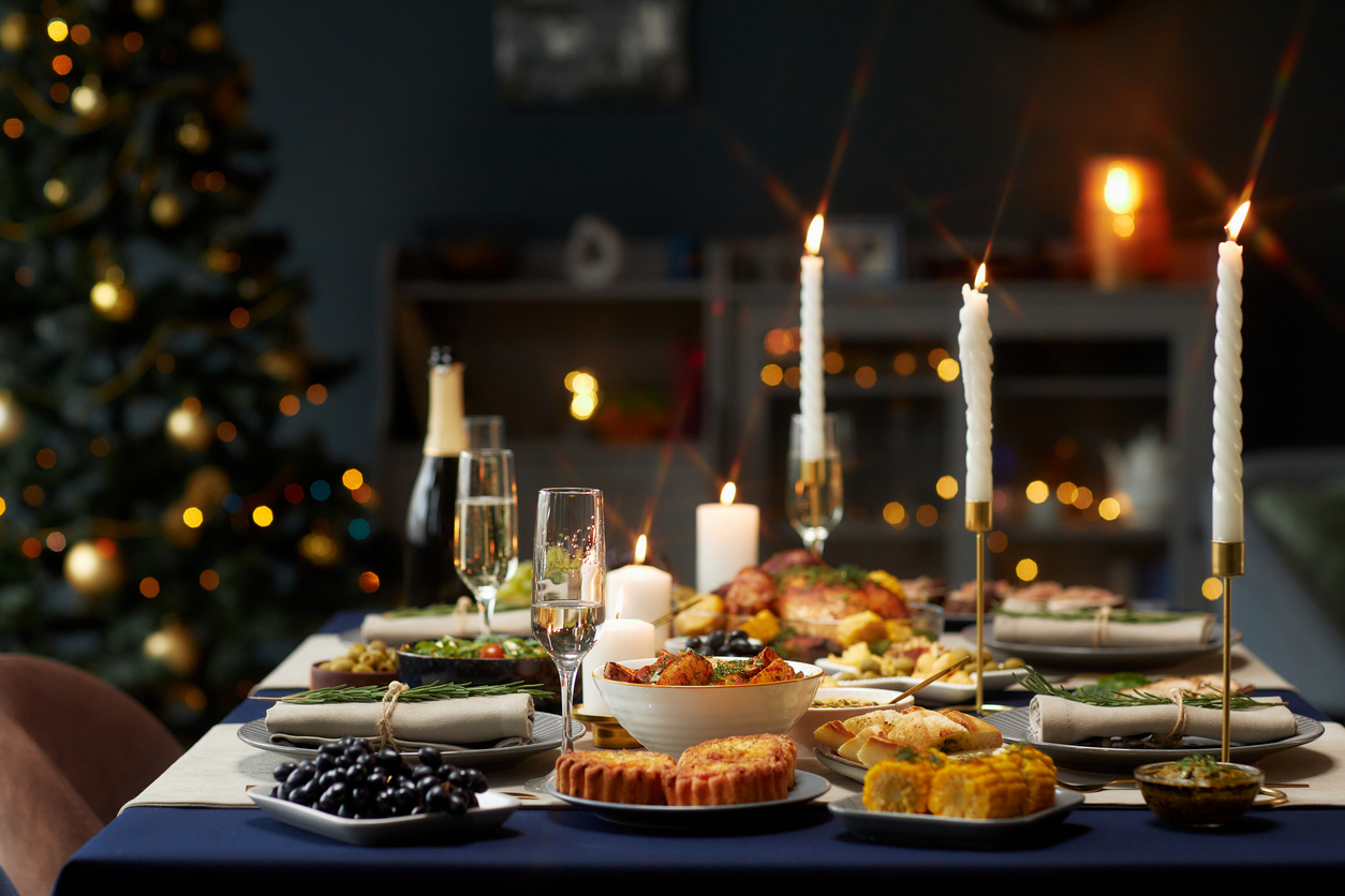 dining table served with champagne flutes and lit candlesticks at christmas