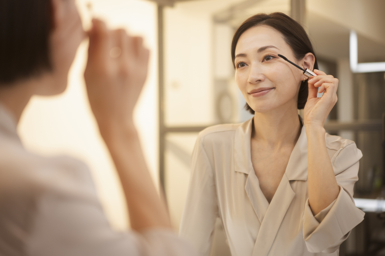 a woman wearing makeup in front of a mirror