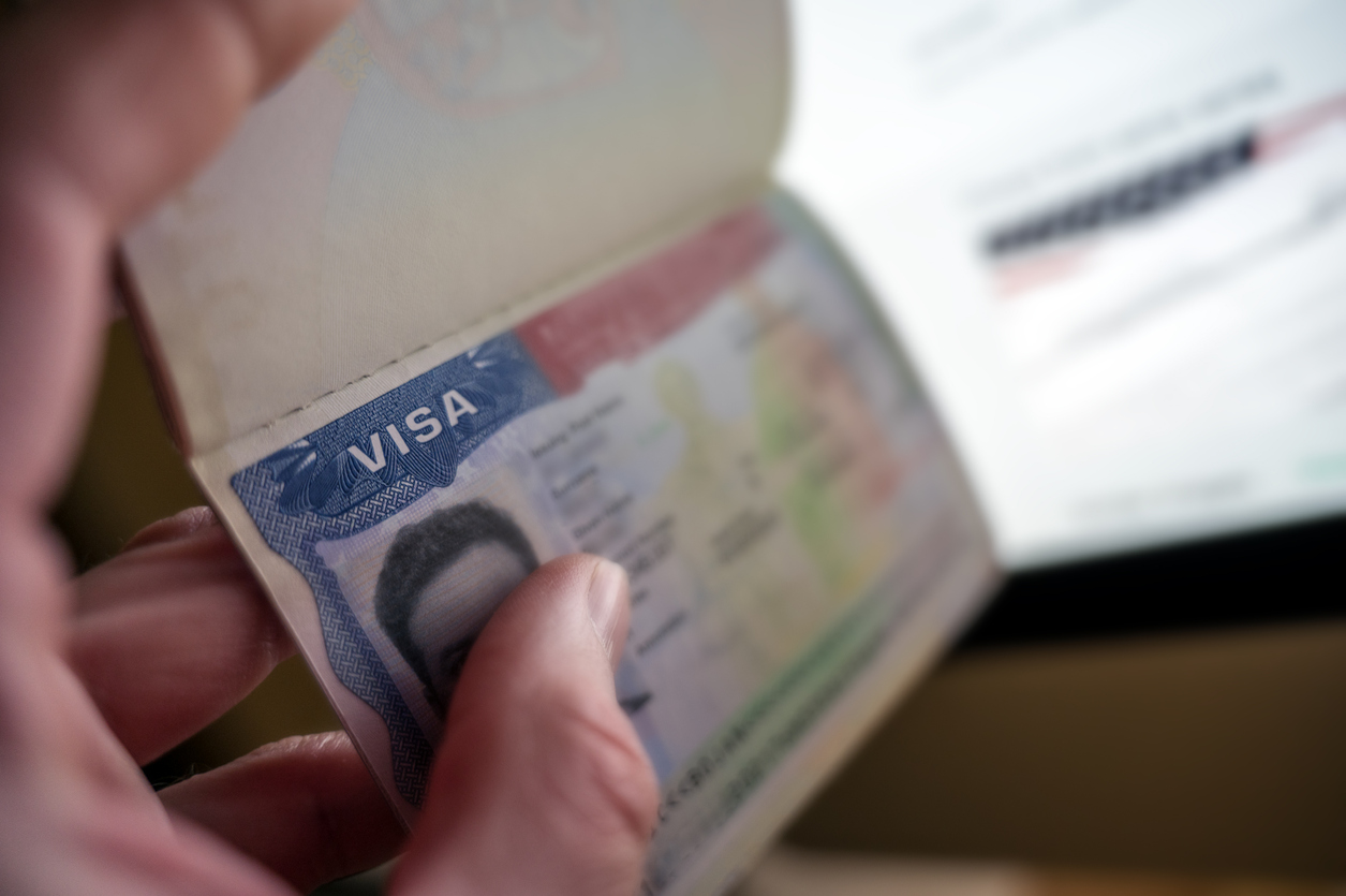 unknown causian person holding passport with visa