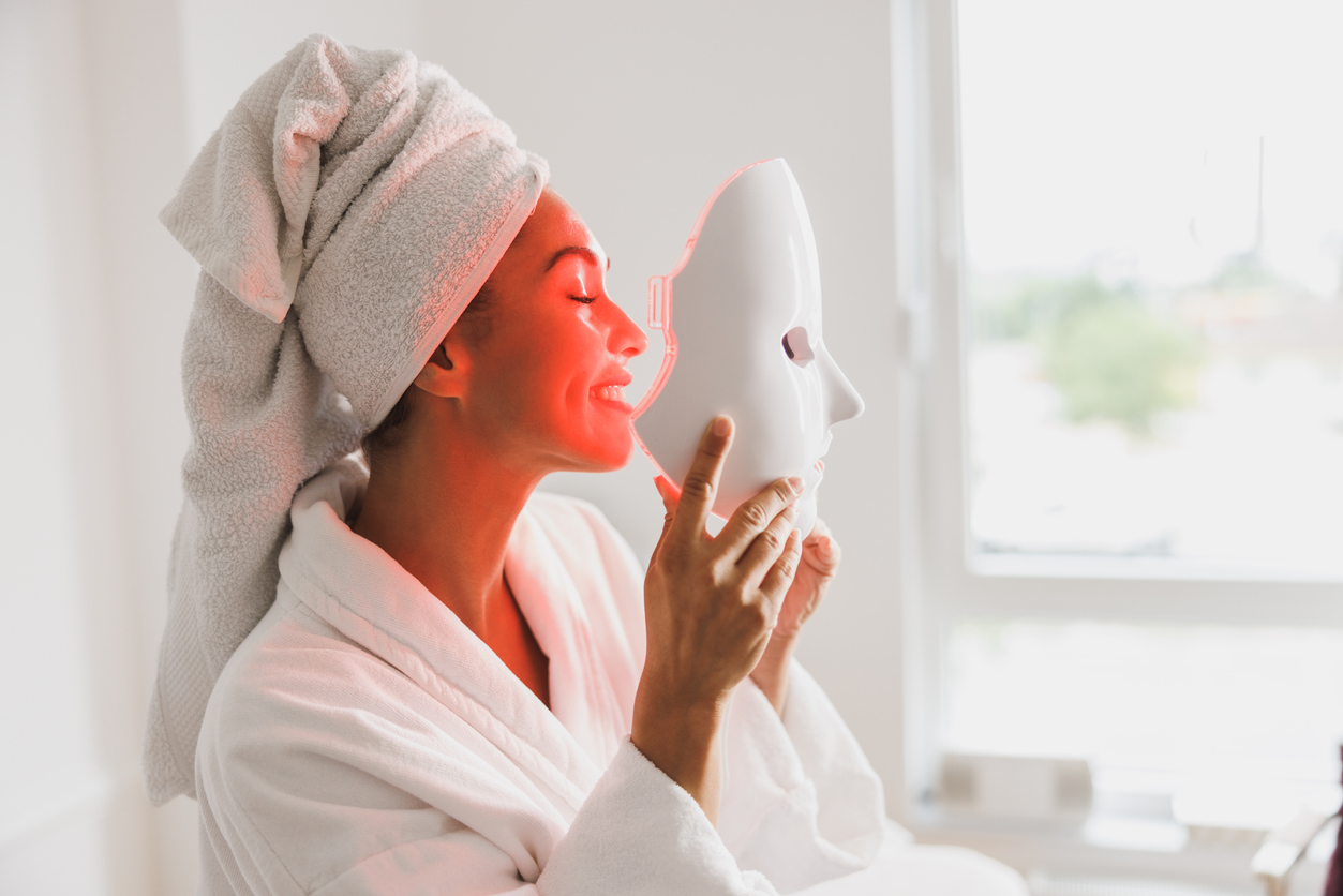 woman getting a led light facial mask treatment at the beauty salon