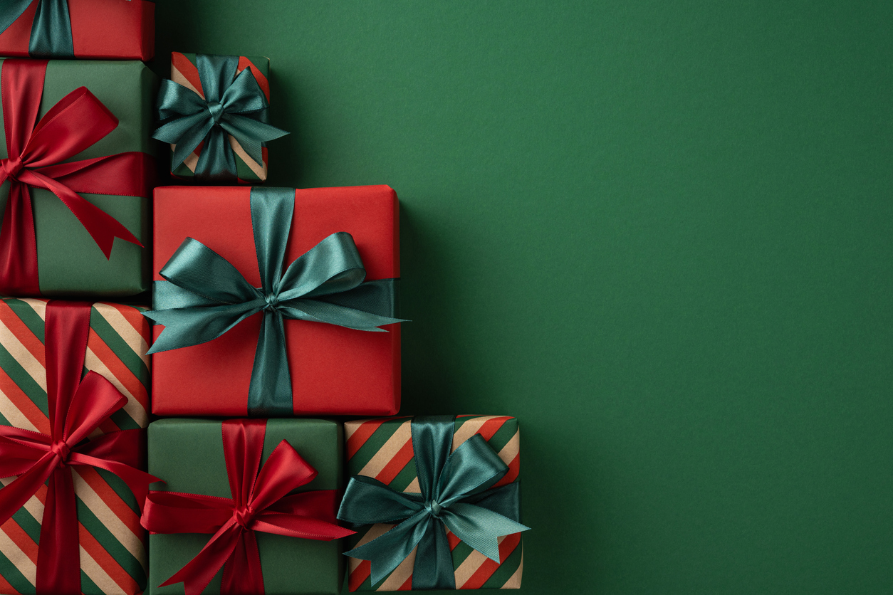 a collection of beautifully wrapped presents in red and green with vibrant ribbons, arranged against green festive background, symbolizing holiday joy, gifting traditions, and the christmas spirit