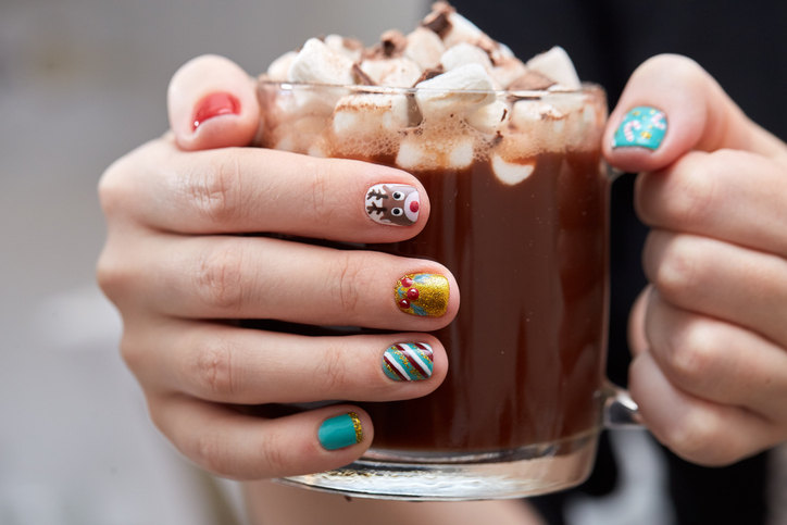 mug with cocoa and marshmallows in female hands.