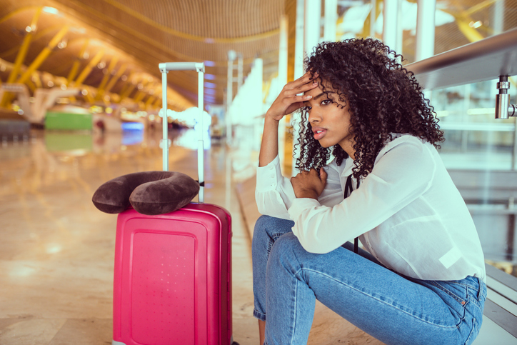 black woman upset and frustrated at the airport with flight canceled