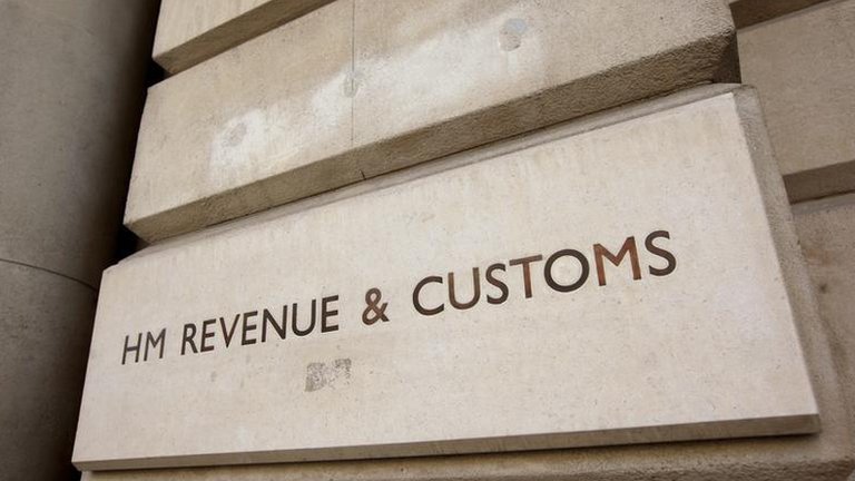 Stone exterior sign reading &ldquo;HM Revenue & Customs&rdquo; mounted on a government building fa&ccedil;ade, representing UK tax authority and public finance regulation.
