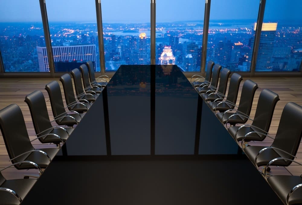 Empty corporate boardroom overlooking a city skyline, symbolizing executive decision-making and institutional power