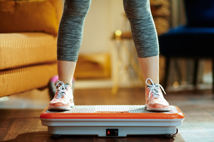 closeup on young woman training using vibration power plate