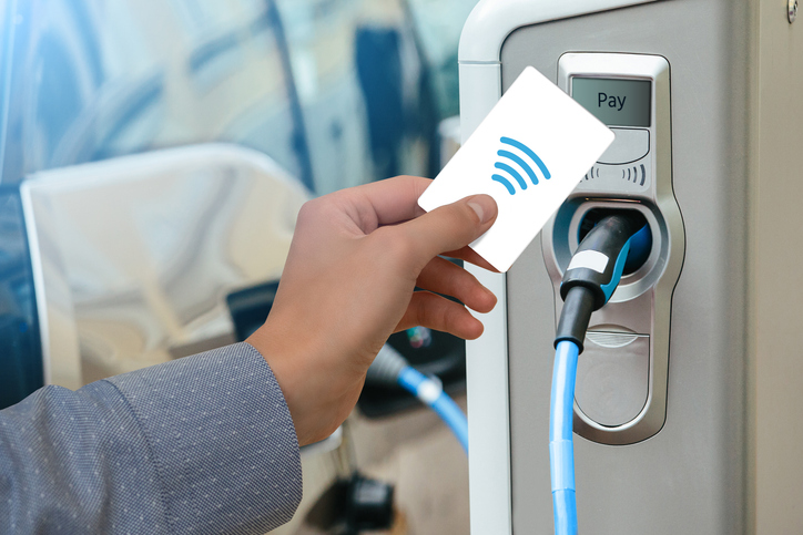 a man pays on charging station