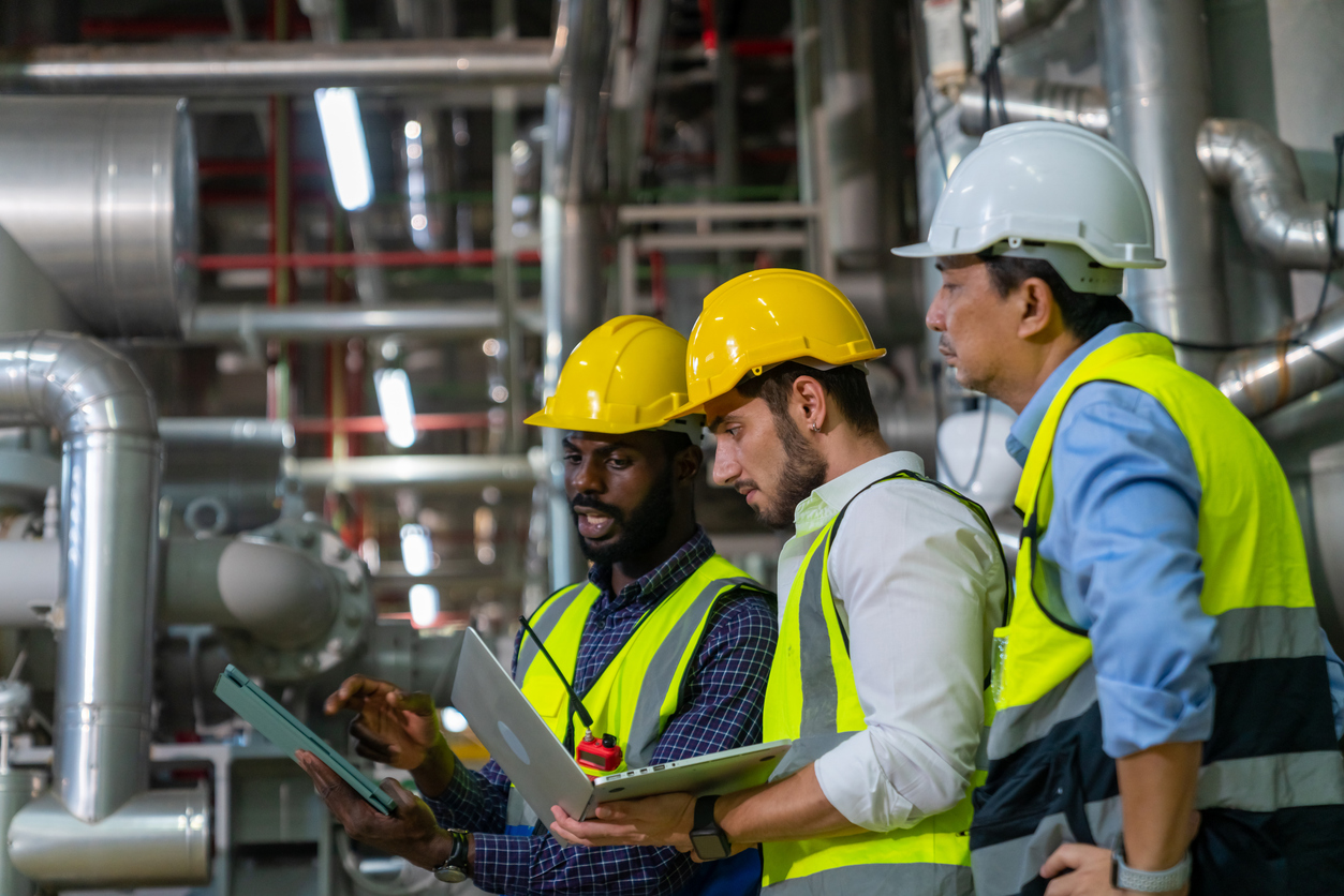 group of male engineer working together at factory site control room.