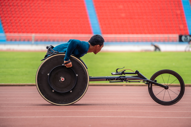 asian young man para athletes disabled practice handcycling in stadium. attractive amputee male runner exercise and practicing workout for paralympics competition regardless of physical limitations.